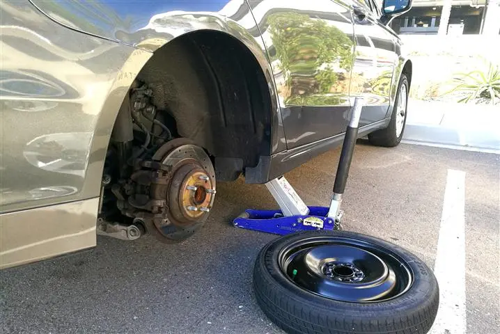 Technician changing a tire on the road in Miami and Broward Counties